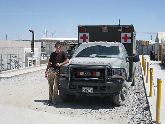 Me stood next to the battle-field ambulance I drove in Kandahar an ambulance in Kandahar